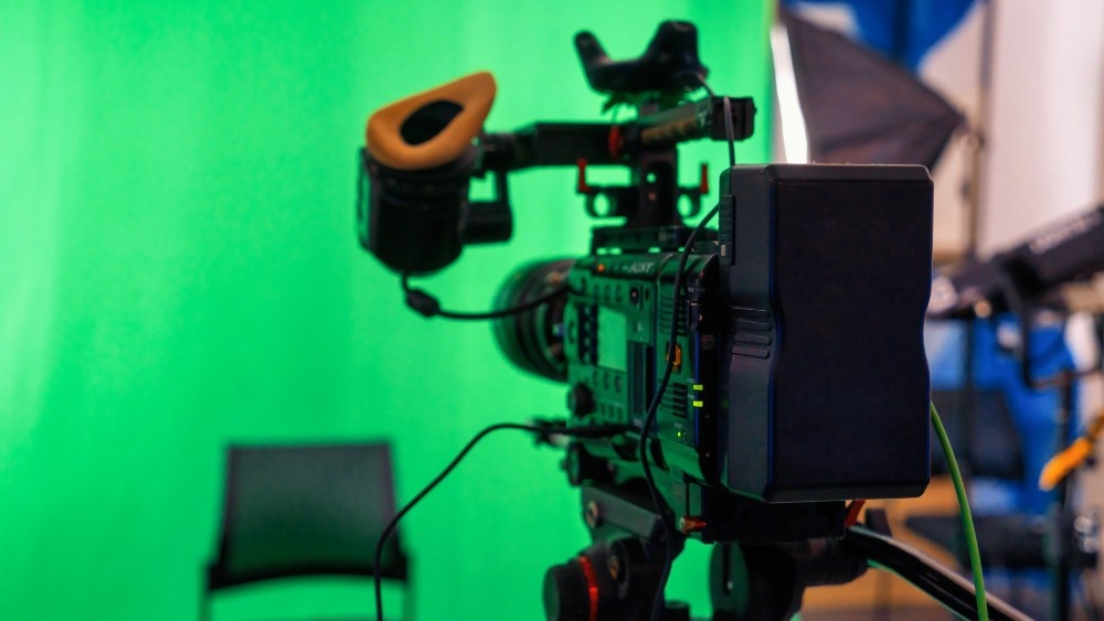 Professional video camera and equipment set up in a studio with a green screen, representing services from a Business Videos Agency in Park Pointe