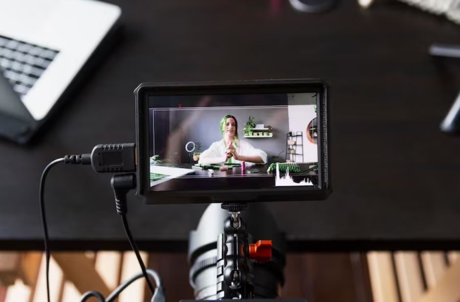 A video camera monitor showing a woman smiling at a desk, ready to be filmed for a corporate video, a service provided by a Corporate Video Production Company in Woodbridge
