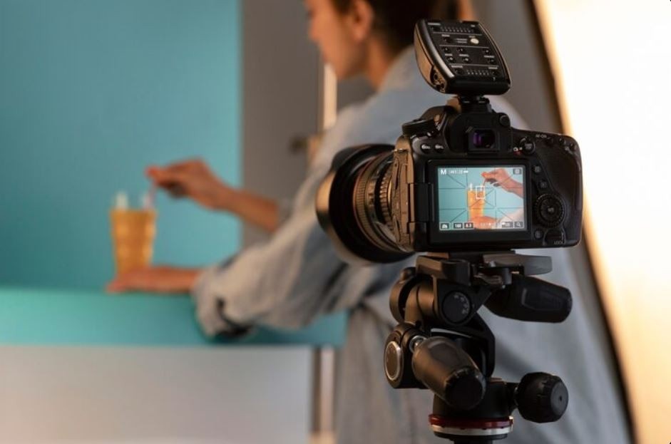 A professional camera on a tripod is focused on a person mixing a drink in a studio setting, showcasing a product video created by a Corporate Video Production Agency in Pheasant Creek