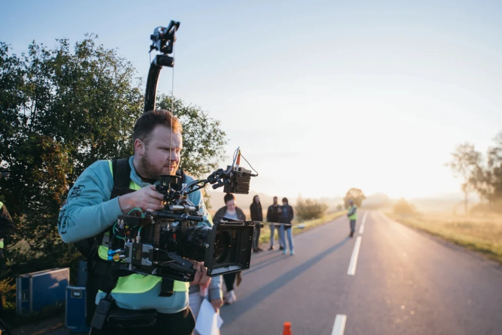 Crew captures cinematic roadside footage for commercial video production Sugar Land using stabilizer rig at sunrise.