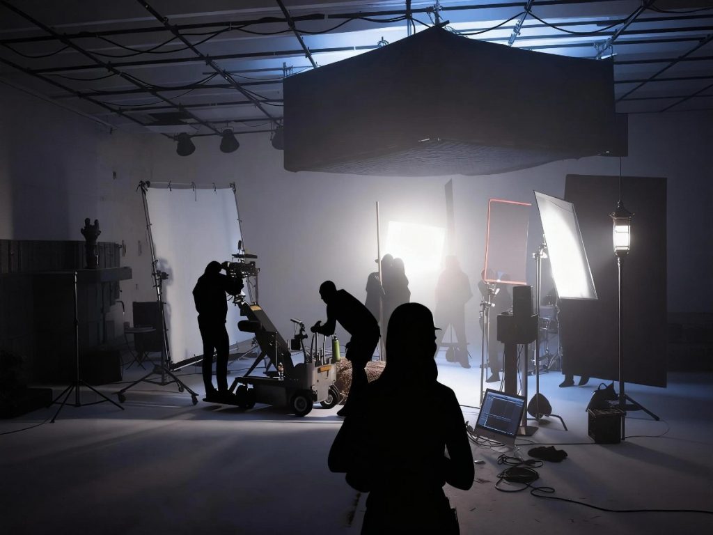 Creative corporate video production company in Sugar Land setting up lighting and cameras for a professional shoot in a well-equipped studio environment.