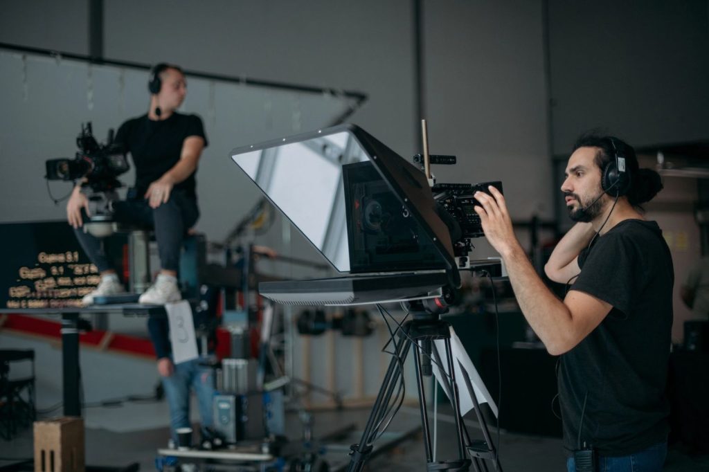 Director adjusting camera setup for Commercial Video Production Company Sugar Land, overseeing a studio production.