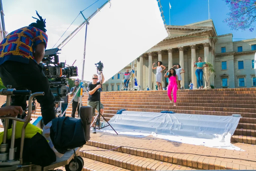 Professional crew filming on grand steps for Commercial Video Production Company Sugar Land outdoor campaign scene.