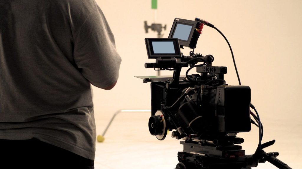 Crew member setting up a camera for a Commercial Video Production Company Sugar Land, preparing for a shoot.