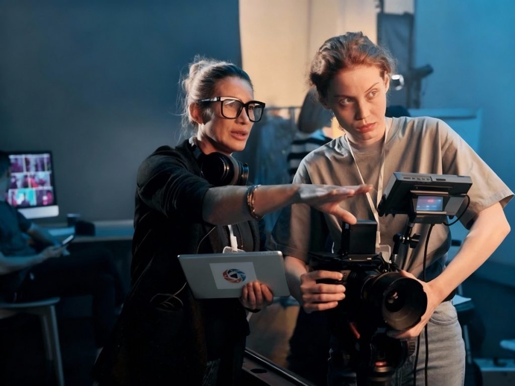 Professional video production team in Sugar Land collaborating on camera setup during a creative filming session in a modern studio environment, ensuring high-quality content for clients.