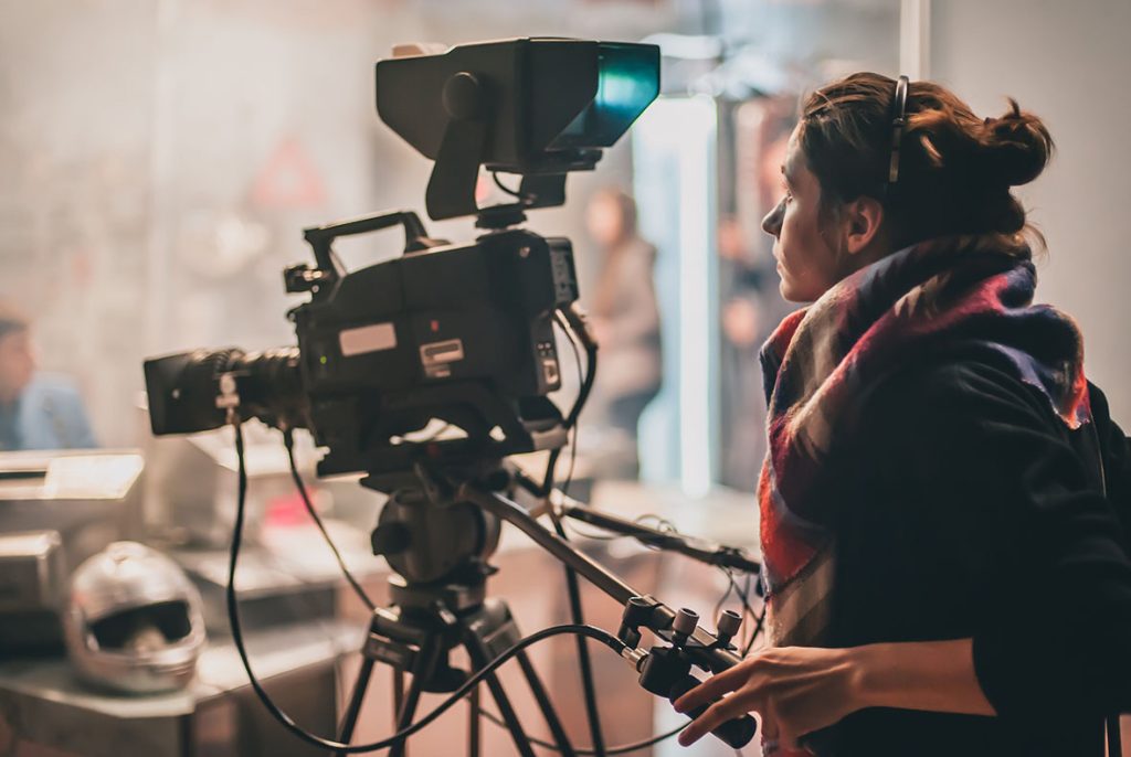 Professional female videographer working with a large camera for promotional videos agency Sugar Land.