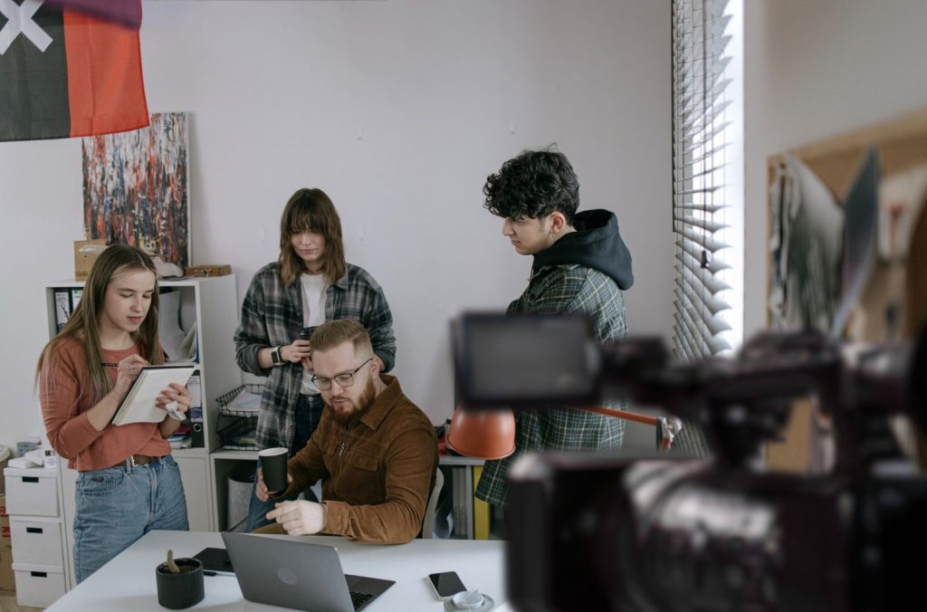 Creative team meeting for a corporate video production agency project in Sugar Land, collaborating and taking important notes.