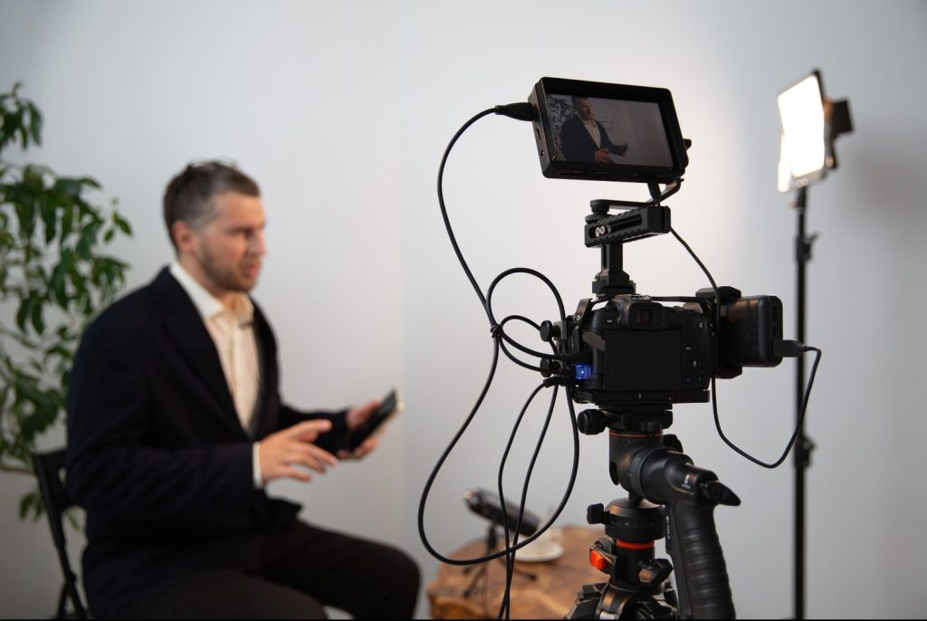 Behind the scenes with a corporate video production company Sugar Land filming a business expert in a studio setting.