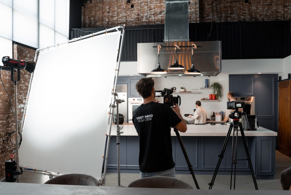 Professional film crew using high-end lighting at a promotional videos agency Sugar Land studio kitchen location.