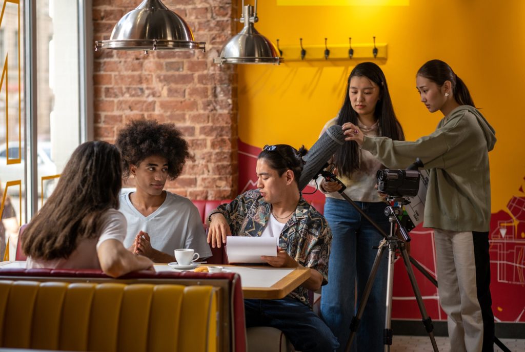 Creative team filming a cafe scene for a promotional videos agency Sugar Land project with professional audio gear.