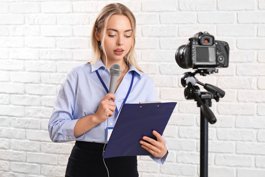 Expert presenter with microphone and clipboard working with a business videos agency Sugar Land on a news set.