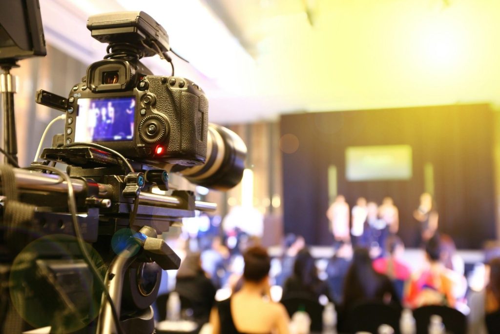 DSLR camera setup by a commercial video production company Sugar Land recording a live keynote at a corporate summit.