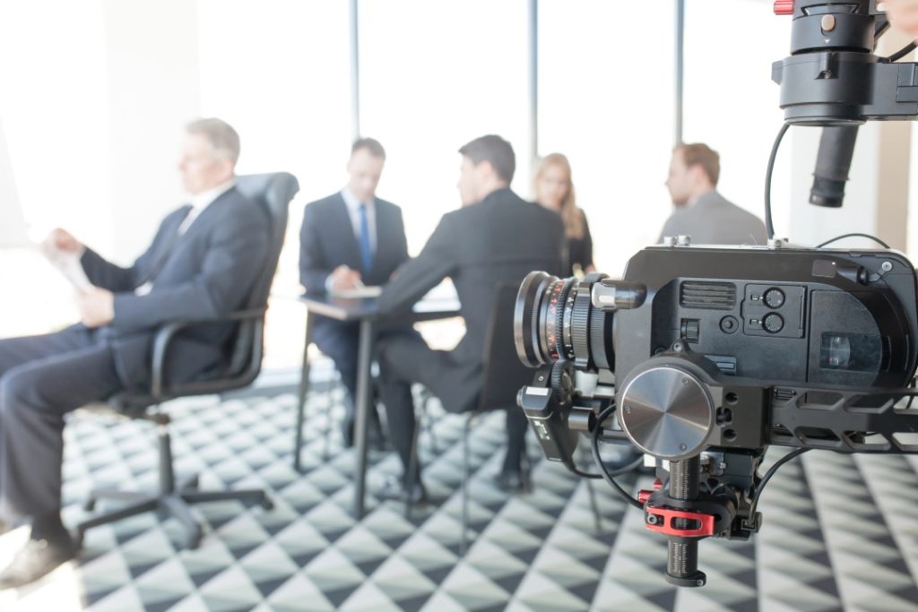 Professional camera gear filming a meeting by a video production company Sugar Land team in a bright modern office.
