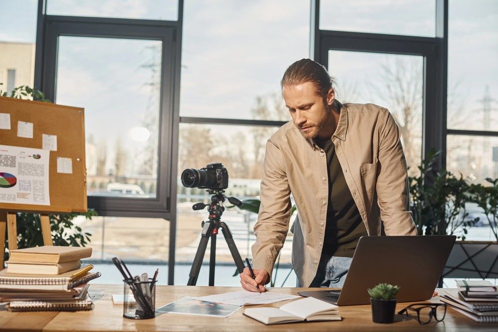 A videographer works on a storyboard in a modern office, planning for a commercial video production company in Sugar Land.